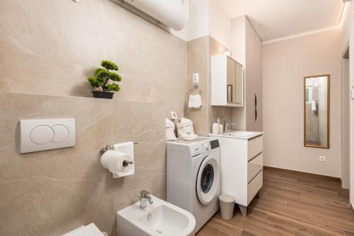 コストレナにあるSeaview Garden Premium apartmentsの洗濯機と洗面台を備えたバスルーム