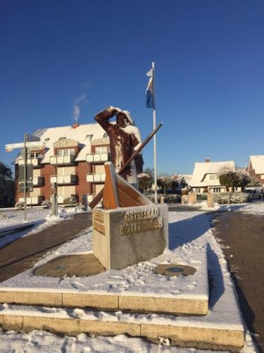 a statue in the snow in front of a building at Haus Strandläufer Wohnung 3 in Kellenhusen