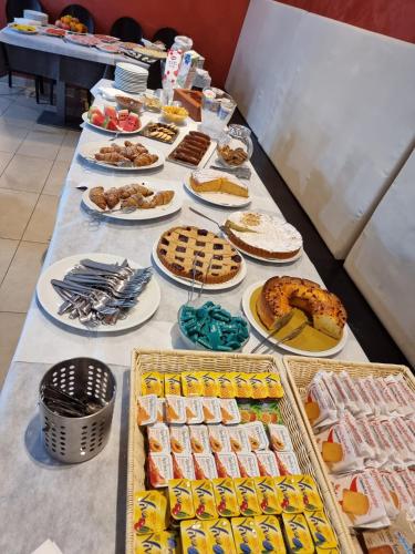 een lange tafel gevuld met verschillende soorten voedsel bij Hotel Morena in Lido di Jesolo