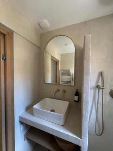 une salle de bains avec un lavabo blanc et un miroir dans l'établissement La Halte des Arènes de Nimes - Appartement Minimaliste - Ecusson Nimes, à Nîmes