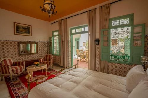 a bedroom with a bed and a table and chairs at Charming Medina Riad 8 rooms with pool - Riad INN Medina in Marrakech