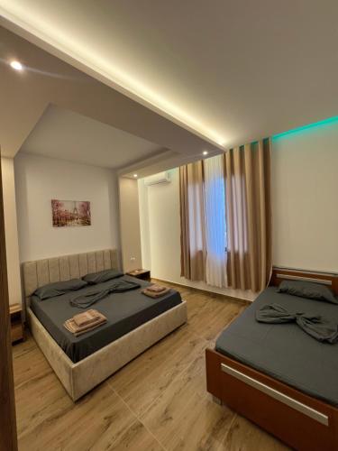 une chambre avec deux lits et un miroir dans l'établissement Joen Apartment 2, à Saranda