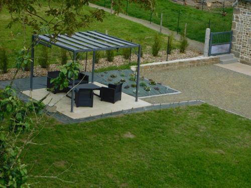 a gazebo with a bench in a park at gite de la laiserie in Mesnil-Clinchamps