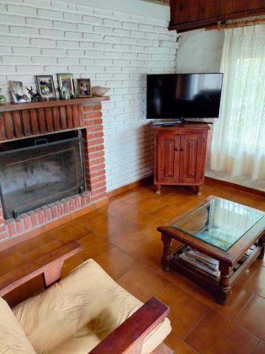 a living room with a fireplace and a flat screen tv at Casa de Playa in Santa Clara del Mar