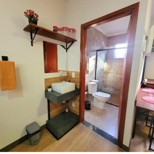 a bathroom with a sink and a toilet at Perfeito Studio 21 in Poços de Caldas