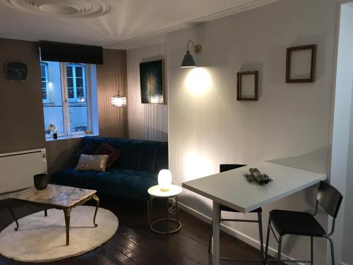 un salon avec un canapé bleu et une table dans l'établissement Studio cosy, à Metz