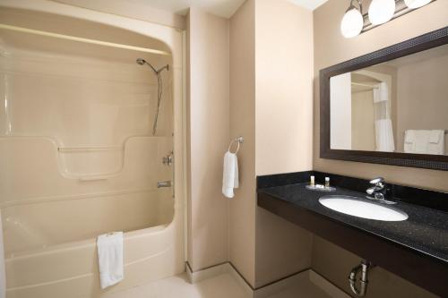 y baño con lavabo, ducha y espejo. en Days Inn by Wyndham Stouffville, en Stouffville