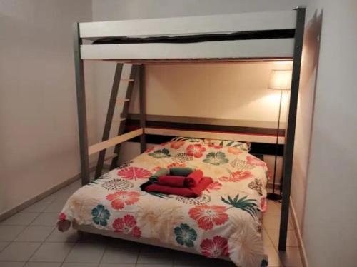 - une chambre avec des lits superposés et un couvre-lit dans l'établissement appartement 4 personnes centre ville argeles sur mer petit prix, à Argelès-sur-Mer