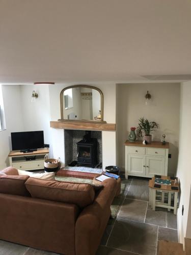 a living room with a couch and a fireplace at Rose Cottage, Little Haven in Pembrokeshire