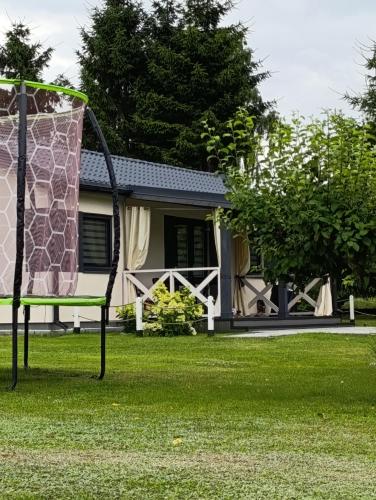 a chair in the grass in front of a house at Domek AlMar in Kołczewo