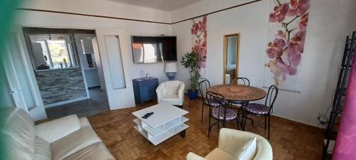 un salon avec un canapé, une table et des chaises dans l'établissement face à la mer, à Propriano