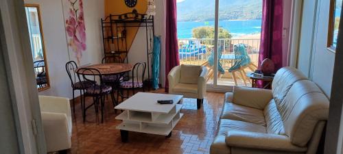 un salon avec un canapé et une table dans l'établissement face à la mer, à Propriano