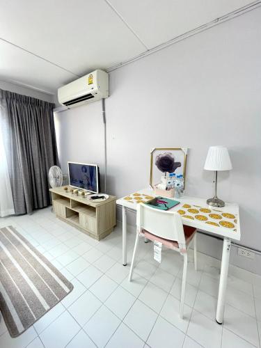 a white room with a table and a chair at Lively Impact C3-C9 in Nonthaburi