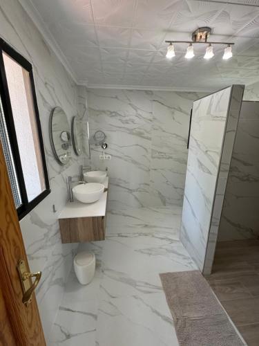 a white bathroom with a sink and a mirror at Villa La Casa de Pintor in Benalmádena
