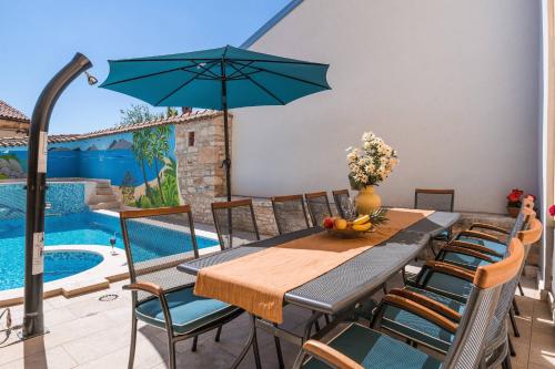 a dining room with a table and chairs and a pool at Villa Nada with 6 bedrooms in Vodnjan