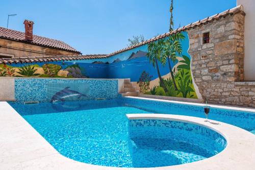 a swimming pool in front of a house with a mural at Villa Nada with 6 bedrooms in Vodnjan