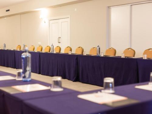 a meeting room with purple tables and chairs at Hotel Santiago Apóstol in Santiago de Compostela