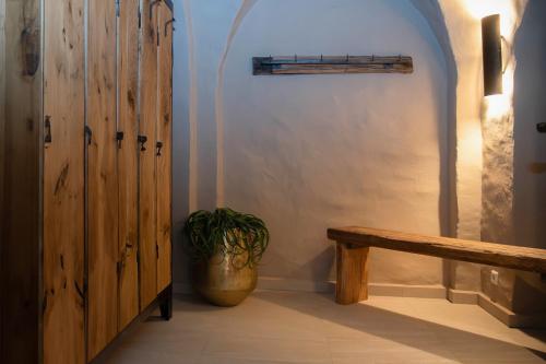 a hallway with a bench and a potted plant at Schloss Rattey - Haus WeinWerk in Schönbeck