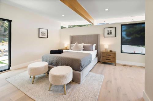 a bedroom with a large bed and two chairs at Sea Vista in Malibu