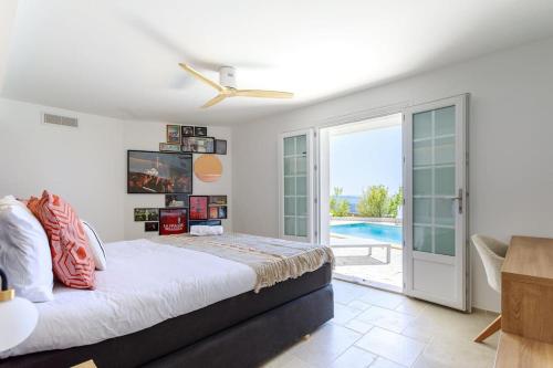 une chambre avec un lit et un ventilateur de plafond dans l'établissement La Grande Bellezza, à Mandelieu-la-Napoule