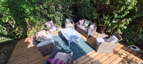 une terrasse en bois avec des chaises et une table avec dans l'établissement Charmant rez-de-jardin, 90 m2, à deux pas d'Avignon, à Villeneuve-lès-Avignon
