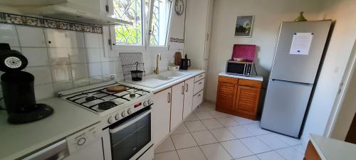une cuisine avec une cuisinière et un réfrigérateur dans l'établissement Charmant rez-de-jardin, 90 m2, à deux pas d'Avignon, à Villeneuve-lès-Avignon