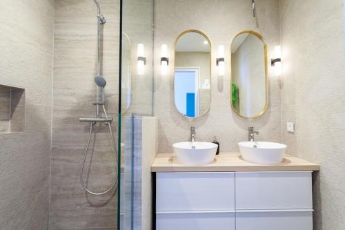 une salle de bain avec deux lavabos et deux miroirs dans l'établissement La Grande Bellezza, à Mandelieu-la-Napoule