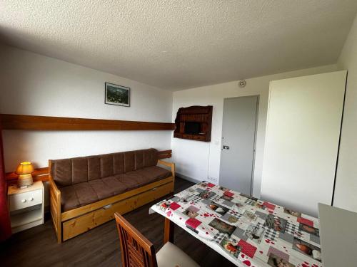 un salon avec un canapé et une table dans l'établissement Studio cosy pour 2 pers, centre des Menuires, au pied des pistes - FR-1-452-273, aux Menuires