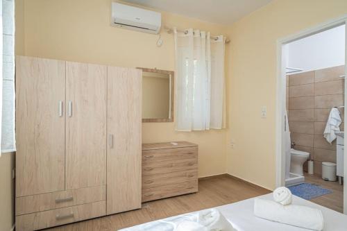 a bathroom with a large wooden cabinet and a toilet at Mariana Sea View Apartment in Kefallonia