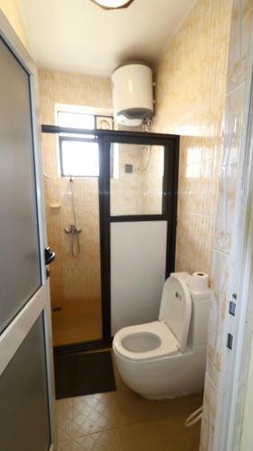 a small bathroom with a toilet and a shower at Peponi Living Spaces in Kigali