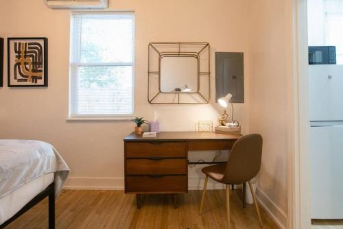 a bedroom with a desk with a mirror and a bed at Oakdale Suites - Master Property in Medford