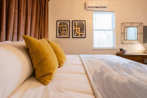 a bedroom with a bed with yellow pillows on it at Oakdale Suites - Master Property in Medford