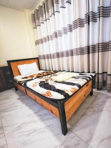 a bed in a room with a curtain at Peponi Living Spaces in Kigali
