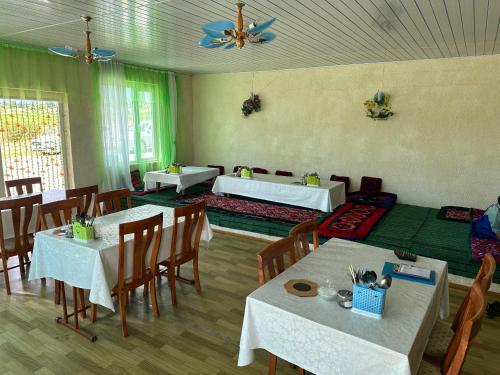 a dining room with white tables and chairs and a ceiling at Кут in Bosteri