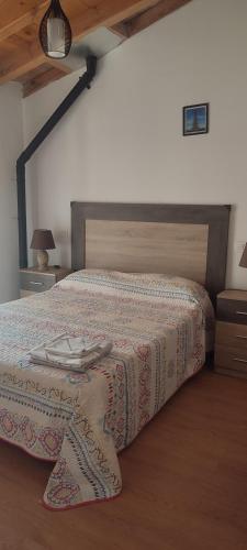 Un dormitorio con una cama con una manta encima. en Casa Bergón en Fuentenebro Ribera del Duero Burgos, en Fuentenebro