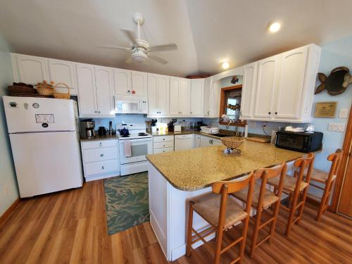 a kitchen with white cabinets and a white refrigerator at Barney's Roost in Sanderling
