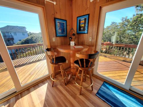a room with a table and chairs on a deck at Barney's Roost in Sanderling