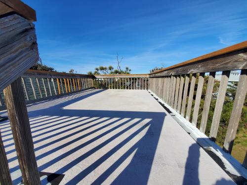a walkway with a wooden fence and its shadow at Barney's Roost in Sanderling
