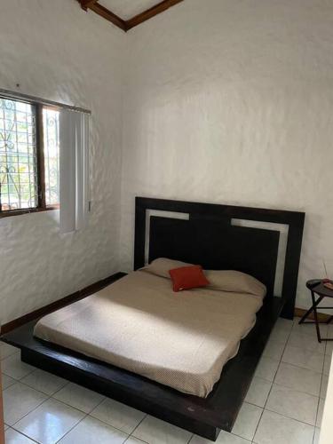 a bedroom with a bed with a red pillow on it at Green place apartament in Quesada