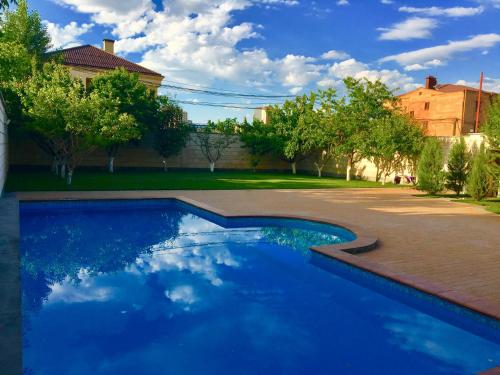 a blue swimming pool in a yard with trees at Luxury villa in Yerevan