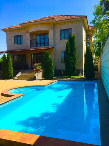 エレバンにあるLuxury villaの家の前にプールがある家