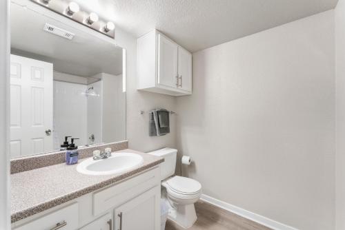 a white bathroom with a sink and a toilet at Spacious 2BR King Suites w Pool, Gym, Laundry - Close to Downtown in Austin
