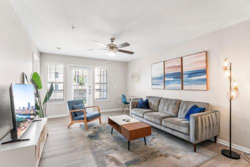 a living room with a couch and a tv at Spacious 2BR King Suites w Pool, Gym, Laundry - Close to Downtown in Austin