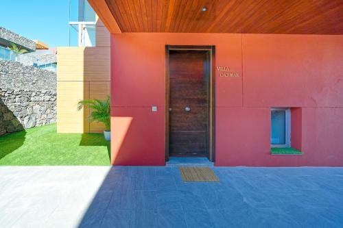 a red building with a door with the words trial coach at Villa Cacemar Salobre Golf in Las Palmas de Gran Canaria