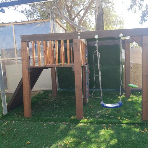 a playground with a swing at חצבים על הואדי in Arad
