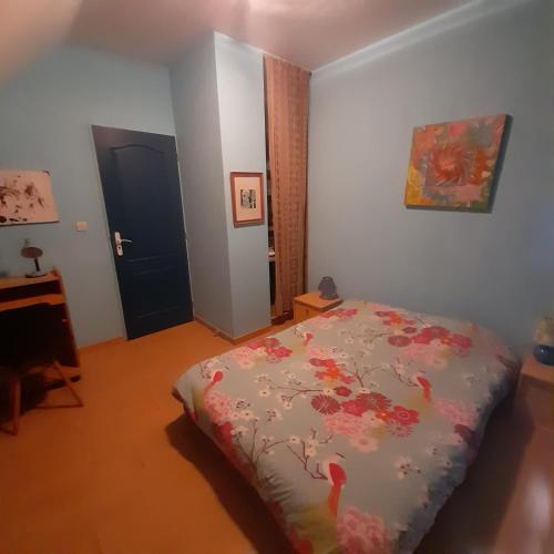 a bedroom with a bed and a desk and a door at Guernazelles in Le Controis En Sologne