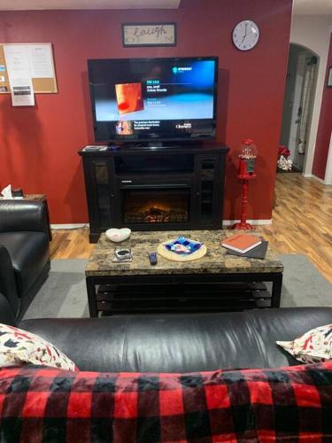 a living room with a couch and a television at Cozy Lodge Suite in Sylvan Lake