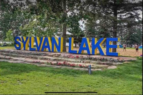 a sign that says swan lake in a park at Cozy Lodge Suite in Sylvan Lake