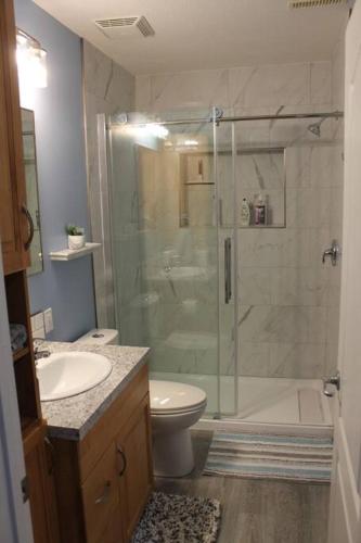 a bathroom with a shower and a toilet and a sink at Cozy Lodge Suite in Sylvan Lake
