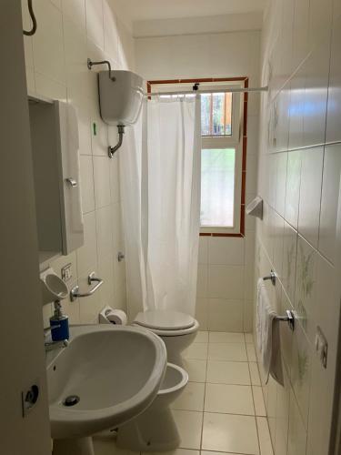 a white bathroom with a toilet and a sink at Villetta in pineta in Gallipoli